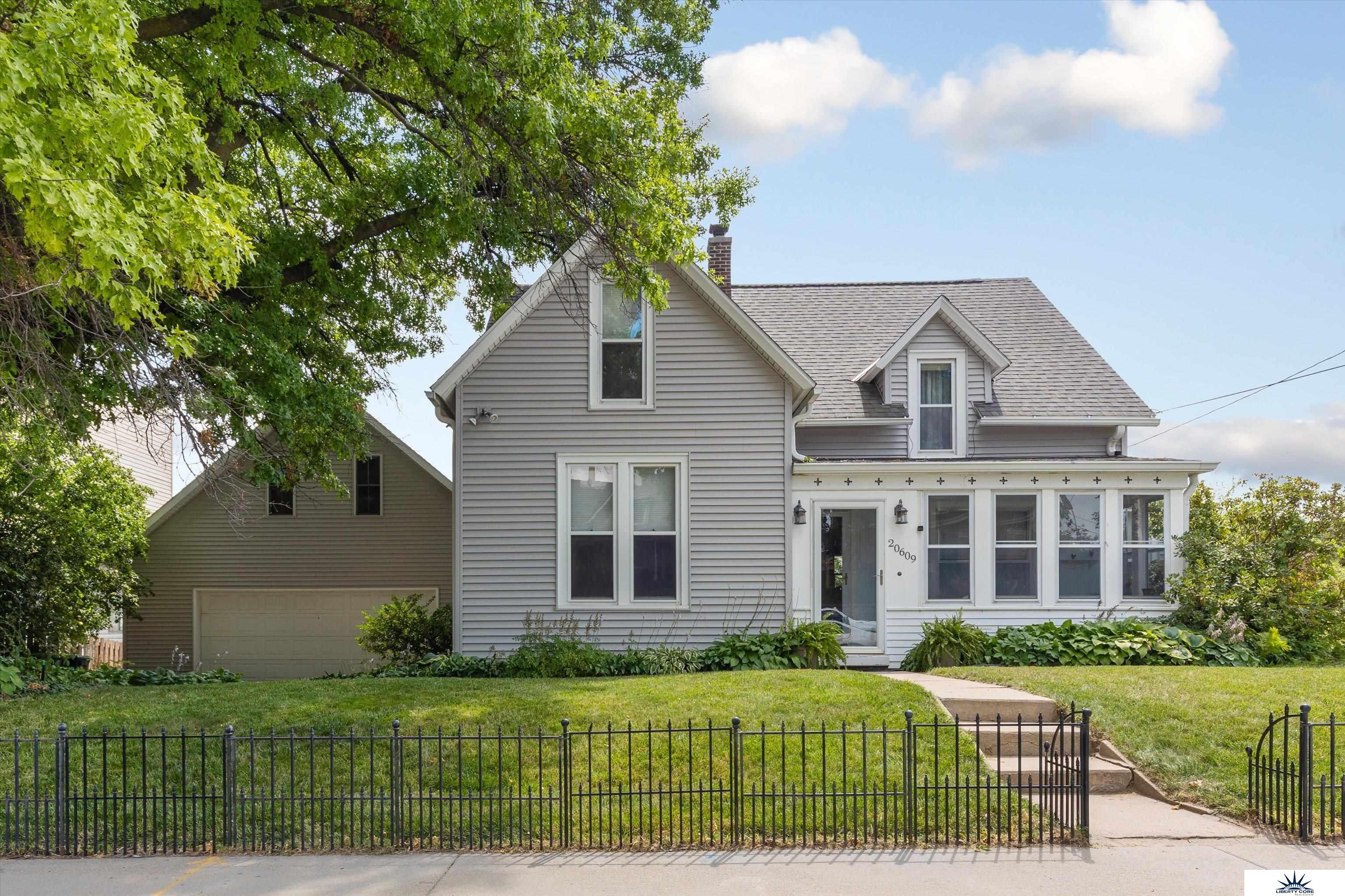 Nestled in the charming Old Town Elkhorn district, this property offers a rare and exciting investment opportunity. Whether you choose to rather redevelop, or utilize the already active Airbnb home on the premises, the potential for this space is limitless. Settled next to multifamily, commercial and open lot. Step inside the home to discover original woodwork and doors, hardwood floors, and tall windows that flood the space with natural light. This home can sleep 10 plus occupants making this a very attractive Airbnb during CWS, holidays and throughout the year. There is an oversized two car garage with loft above. The large back deck, brick sidewalk, and patio provide the perfect outdoor entertaining space, while the private backyard boasts beautiful landscaping with large mature trees, flowers, and grasses. Don't miss your chance to own a piece of Old Town Elkhorn history. Come see all that this unique property has to offer.