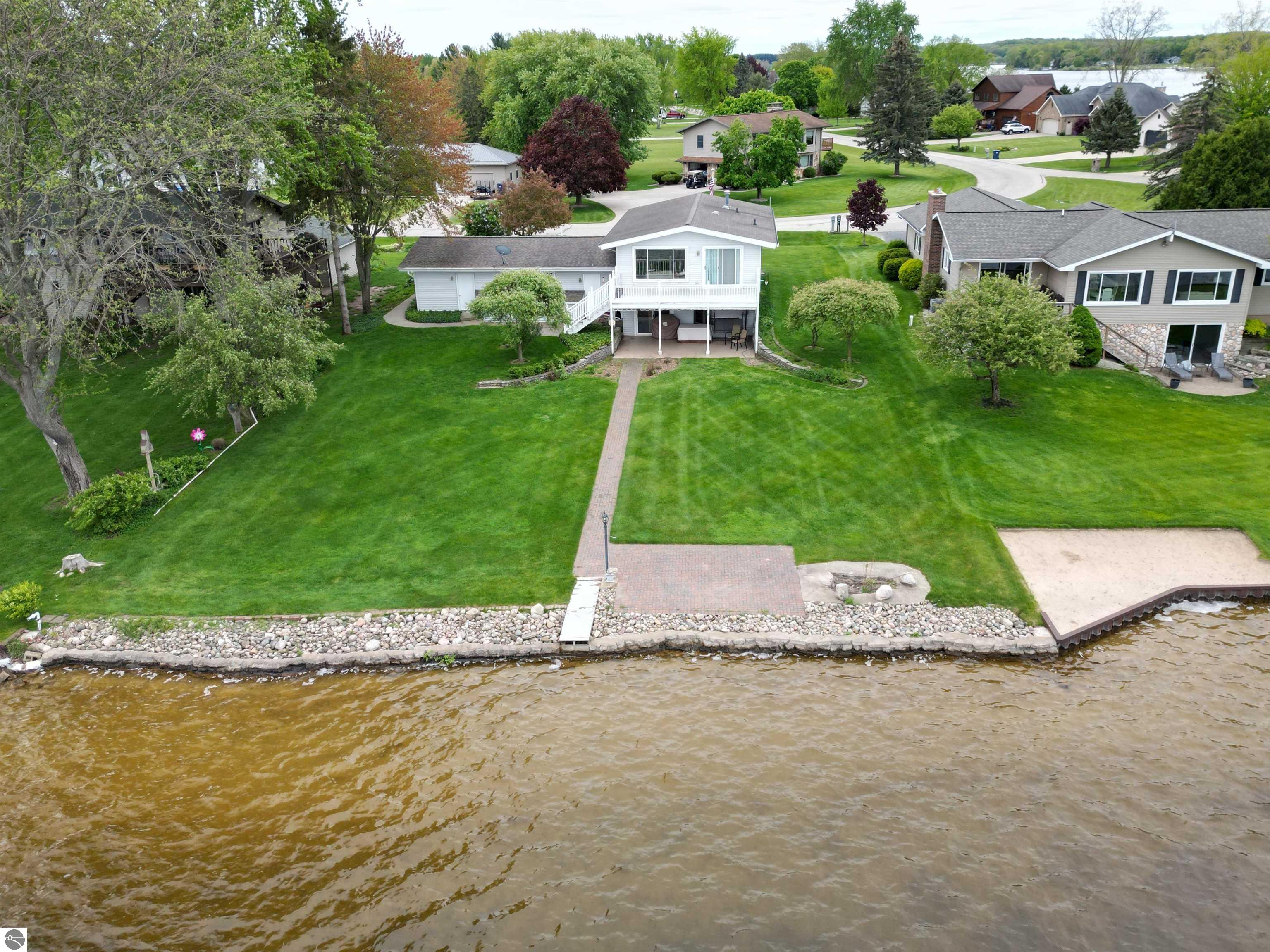 THE LAKE HOUSE. A prime location. Situated right where the action is on the east side of Lake Isabella, this home has 90' on the lake and a great neighborhood full of activity with joggers, bikers, and golfers. This split-level home features 3 bedrooms and two bathrooms. The open plan has plenty of room for entertaining. The kitchen features hickory flooring and cabinetry, Corian counters, kitchen island, and breakfast bar. All appliances are included. Great natural lighting. Custom walnut railings. Family room and lower level walkout to covered patio. 3-car garage. Irrigation system. Private dock. Sea wall. Lake Isabella is a private 800-acre all sports lake. The Pines Golf Course is just up the street with Pro Shop and Clubhouse. Tally's (inside Clubhouse) is open year round for lunch, dinner, and live entertainment. Mt Pleasant is only 15 minutes west with CMU, Soaring Eagle Casino, and Water Park. Fast Possession! Act today!