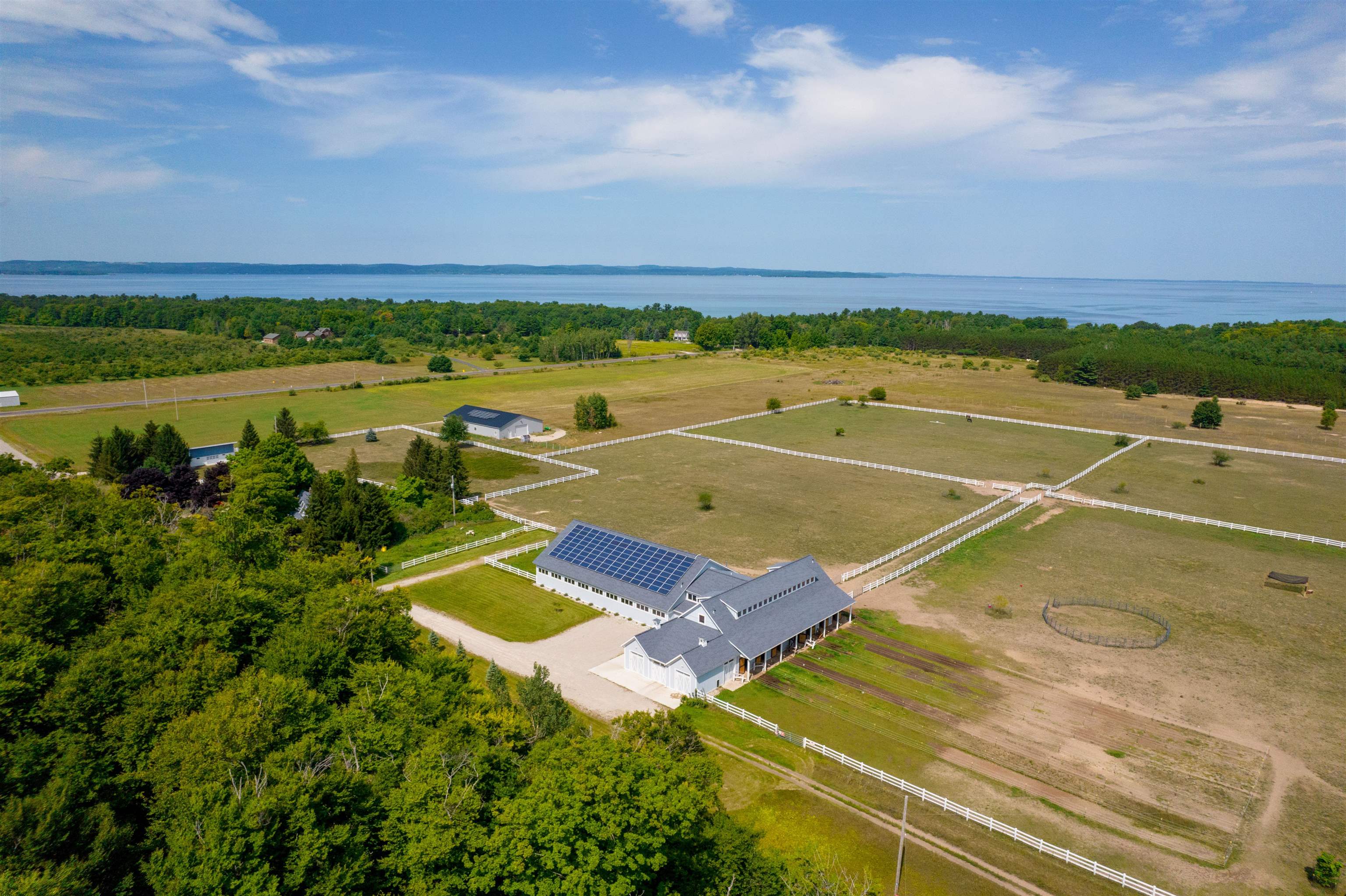 Here is your chance to own a fully working farm on the coveted Old Mission Peninsula in Traverse City, Michigan! Sprawling over 126 acres and consisting of 5 parcels, this property has a rare 300' of private sandy water frontage on West Grand Traverse Bay, an operating equestrian facility, a turn of the century farm house, and multiple outbuildings. Complete with livestock including 4 Rocky Mountain horses and 7 purebred Great Pyrenees guard dogs. The land has 2000+ Christmas trees, 300+ lavender Vera plants, and 15 acres already in rotational crop. The equestrian barn, built in 2016, features 9 stalls, garage doors for work vehicles, saddle room, employee break room and laundry, grooming areas, and an expansive 60x100 heated dirt arena for working the horses. Walking upstairs, you will find a large office space with picture windows overlooking the stalls and a viewing balcony for the training arena. There are multiple outbuildings on the property including a newly built (2020) pole barn currently used for hay and tractor storage. Equipment, tack, and feed included with property - perfect for an experienced/aspiring farmer or equestrian enthusiast. Surrounded by beautiful Traverse City countryside with only a short walk to your own private sandy beach on the bay, this is an opportunity you do not want to miss!