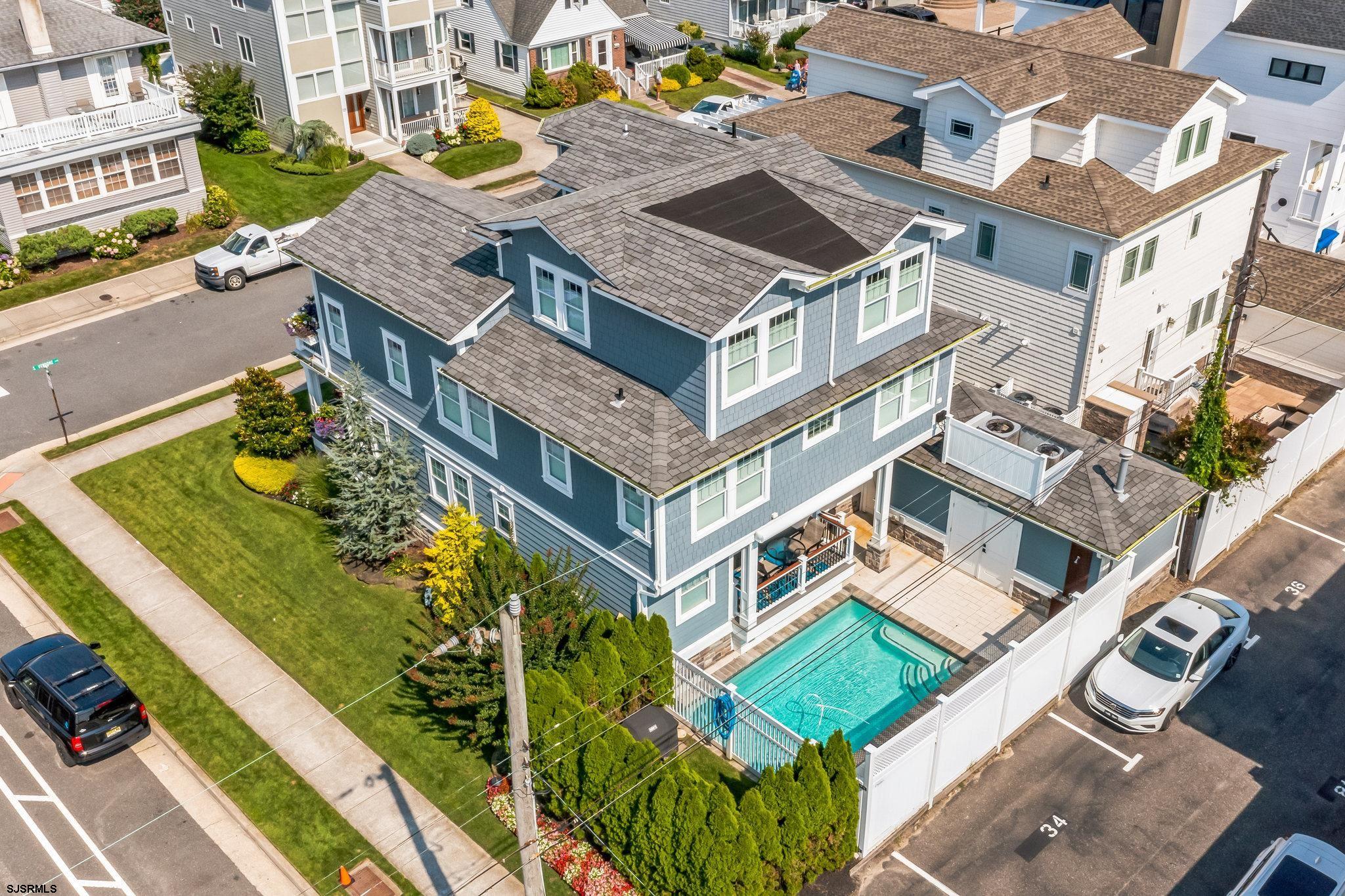 Beach Block Coastal living at its finest in the heart of Margate. This stunning corner  property featuring IN-GROUND POOL, 6 bedrooms and 5 baths is the epitome of the perfect beach house to gather with family & friends.  From the moment you step onto the covered front porch, you discover the enjoyment of relaxation at the Jersey shore. The delightful front porch invites you into the main living area with fireplace and an open design highlighted by high end finishes along with beautiful hardwood flooring throughout this beach house.  The chefs kitchen is delightful and equipped with a large walk in pantry and a spacious center island along with a comfortable dining area. The Sliding glass doors off the kitchen invite you to a covered deck which overlooks the in-ground pool, a great retreat to relax and entertain. Direct access from pool is (1) of (2) laundry areas and a full bath, perfect for use after the beach and pool. Located on a beautiful bright beach block corner with a lot size of 56’ x 80’, this beach house offers 6bd, & 5 baths with the second level showcasing the primary ensuite with deck and ocean views. Also featuring 3 guest bedrooms and 2 baths and an additional laundry area. The third level offers 2 additional bedrooms and a bathroom, a perfect layout for extended family and guests. Also featuring a detached garage and off street parking!  Don't miss this wonderful opportunity to own a beach house and enjoy the Margate fun life with amazing restaurants and activities for all ages.