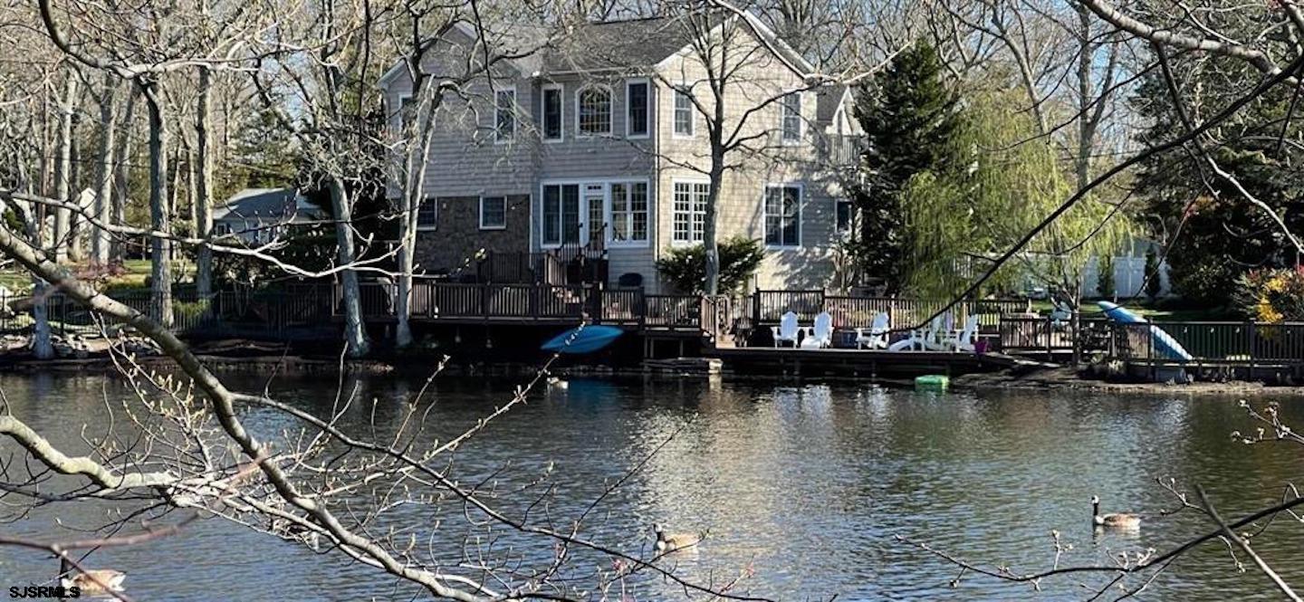 Rare Opportunity to live Lakefront AND in Linwood on a culdesac! An entertainer's dream -  indoors and outdoors, A garden-lover’s paradise, a birder’s delight and where everyone can enjoy year-round fishing, kayaking, boating, paddle boarding, winter ice fishing, ice hockey & skating and more. Plus 2 firepit areas & two hammock areas to relax and reflect and watch waterfront sunrises to the east and stunning sunsets to the west! Steps to EVERYTHING Linwood has to offer - bike path, all 3 top rated schools, ball fields, parks, Jessie’s (IYKYK) all while being just 15 minutes door to door to the Atlantic City casinos, the Margate and Longport beaches, and the Ocean City Boardwalk. But this home is not for everyone - there are some projects still to be completed here for this special property to reach its fullest potential! Phase 1 of this home's renovation was 15 years ago by Linwood Custom Builders to top of the line specifications and included the entire exterior, windows & roof, the addition and framing of the new huge Master bedroom ensuite with vaulted ceilings, the bath is pre-plumbed, large his and her closets are framed in, with separate sitting room/5th bedroom addition, the addition of the 2nd set of stairs, the 1st floor impressively renovated entryway, the formal living room, open dining room, family room which is surrounded with water views and lovely powder room. Phase 2 could include renovating the kitchen, opening up the laundry room and Dining room to capture the views from the moment of entry and create an open concept floor plan.  There is an additional foot of ceiling height already built in between the current ceiling and the existing 2nd story floors!! The original 2nd floor section of the home has 3 large bedrooms and 2 full baths.  The ground level section has a perfect hang out room, an enclosed porch with access to the yard, a full bathroom, access to the 2 car garage and access to the enormous finished basement which also has access to the outdoor oasis. This property is being offered with a Bond Membership to the Mainland Recreation Association (MRA)... after a day at the beach, hit the MRA for a dip in the pool, a BBQ and some pickleball/tennis/basketball! Come experience 9 Dartmouth Lane - nothing else like this spectacular home - Winter, Spring, Summer, or Fall - This location offers something amazing for ALL!! See attached for year round photos and take the virtual tour!