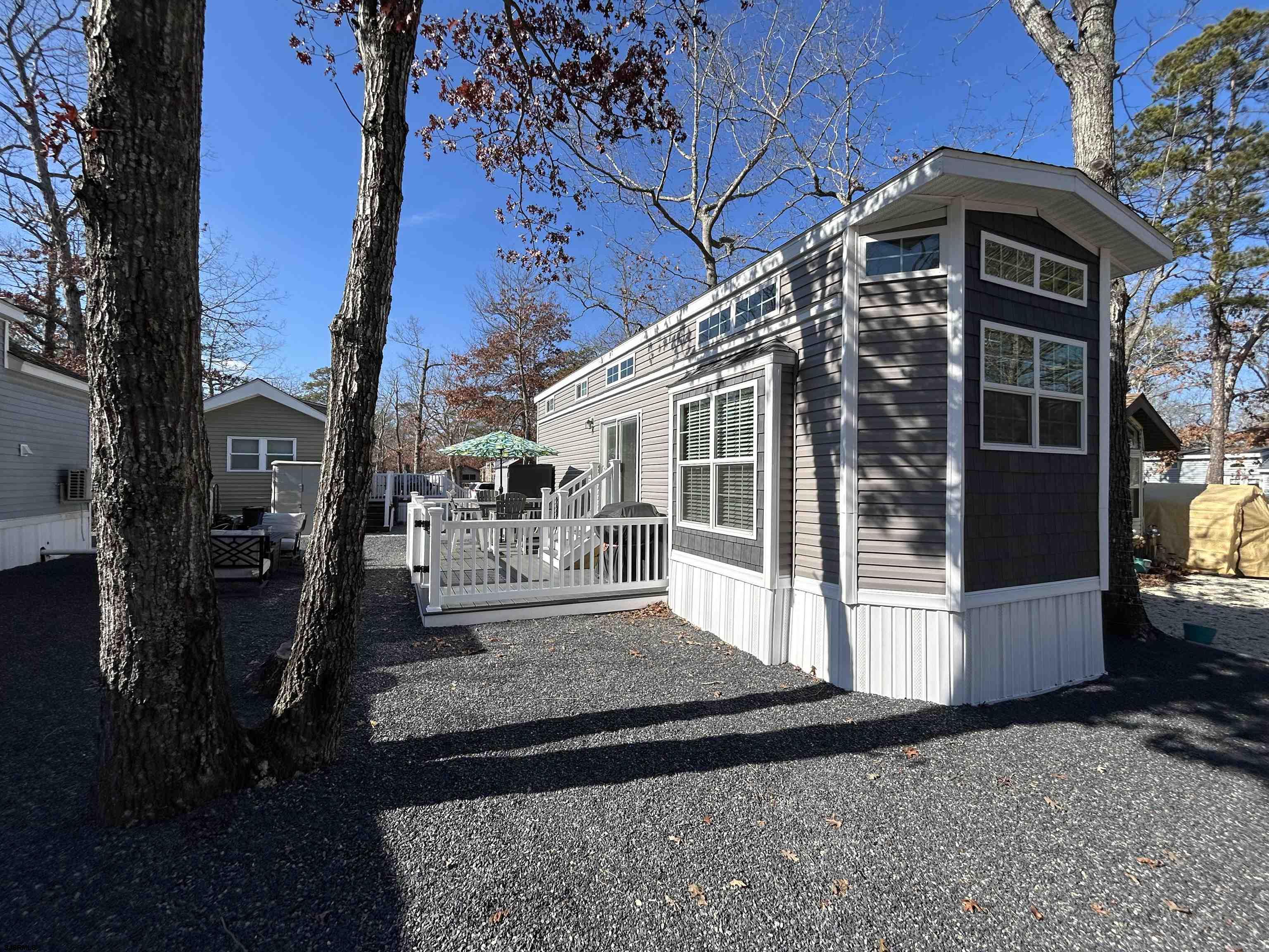 Back on the Market!  Buyer financing fell Through!  Welcome to 35 Harbor Dr at Lake and Shore Seasonal Resort! This stunning 2025 Fairmount Country Manor Park Model offers the perfect blend of modern living and resort-style comfort. Located on the edge of the resort, 35 Harbor Lane boasts an unobstructed view of the tranquil woods across the trail, providing an ideal setting for enjoying your morning coffee as you take in the serene beauty of the coastal Pinelands from your custom composite deck.  Step inside through the sliding glass doors and be greeted by soaring high ceilings, stylish modern finishes, and an abundance of natural light streaming in through multiple windows, seamlessly blending the outdoors with your living space. The contemporary kitchen is equipped with full-size stainless steel appliances, stunning white cabinetry, and generous storage, offering plenty of counter space to prepare meals or drinks for family and friends.  The living room invites relaxation, featuring a full-size couch, a flat-screen TV, and an electric fireplace—a cozy retreat to warm up on chilly winter mornings. The spacious bathroom is tastefully designed with a walk-in shower, offering both style and functionality.  Upstairs, you'll discover a spacious loft—an ideal retreat for guests or additional living space. The loft also includes an auxiliary AC unit, ensuring comfort during those warm summer days.  Back downstairs, you'll find a convenient closet with washer/dryer hookups, as well as ample storage space. The primary sunken bedroom is a serene sanctuary, complete with large windows, plenty of room for your belongings, and a queen-size bed for a restful night’s sleep.  This unit features - Central Air, a large capacity propane tank for cooking and heating.  Flush mount LED lighting, and value  All of this can be found in one of the areas most well known Seasonal Resort Campgrounds - Thousand Trails Lake and Shore.  Featuring a beautiful shimmering sand bottom lake with crystal clear water, a new water park,  camp store and numerous other amenities just minutes to the beach! 35 Harbor Dr. has it all!  Not to mention that the unit comes fully furnished and there is a golf cart that can be negotiated into the deal. what more could you ask for?  So come see this unit before its gone.  Summer is just around the corner.
