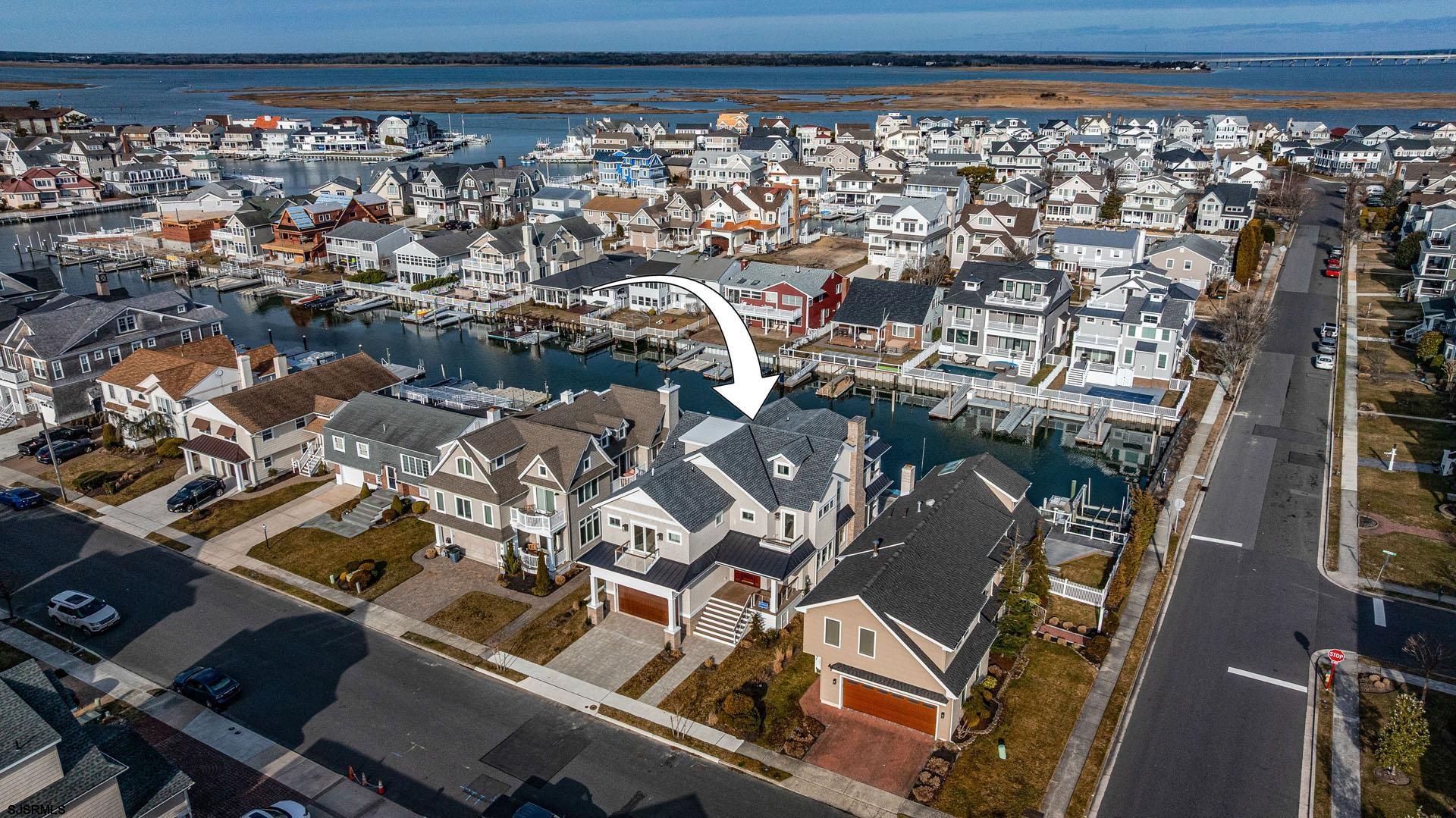 This one has it all!!!  Located on Salvador Harbor in the exclusive Riviera neighborhood, this new construction single-family lagoon front home was designed by Thomas/Bechtold Architecture and built by one of Ocean City's finest custom builders-Price Brothers.  This 2 1/2 story home features 6 bedrooms, 5.5 baths w/ high-end finishes, a chef's gourmet kitchen appointed with an oversized island, top-of-the-line appliance package, custom built cabinetry, wet bar, a 4-stop elevator with custom millwork and hardwood floors throughout. Exterior features include NuCedar shake siding, single seam metal roofing, brick foundation, stainless steel cable rail system with mahogany capping, a gunite pool, an outside enclosed shower, multiple decks, 2 car garage with a boat slip, and much more.  For a virtual tour, please visit https://vimeo.com/1061963806?share=copy#t=0