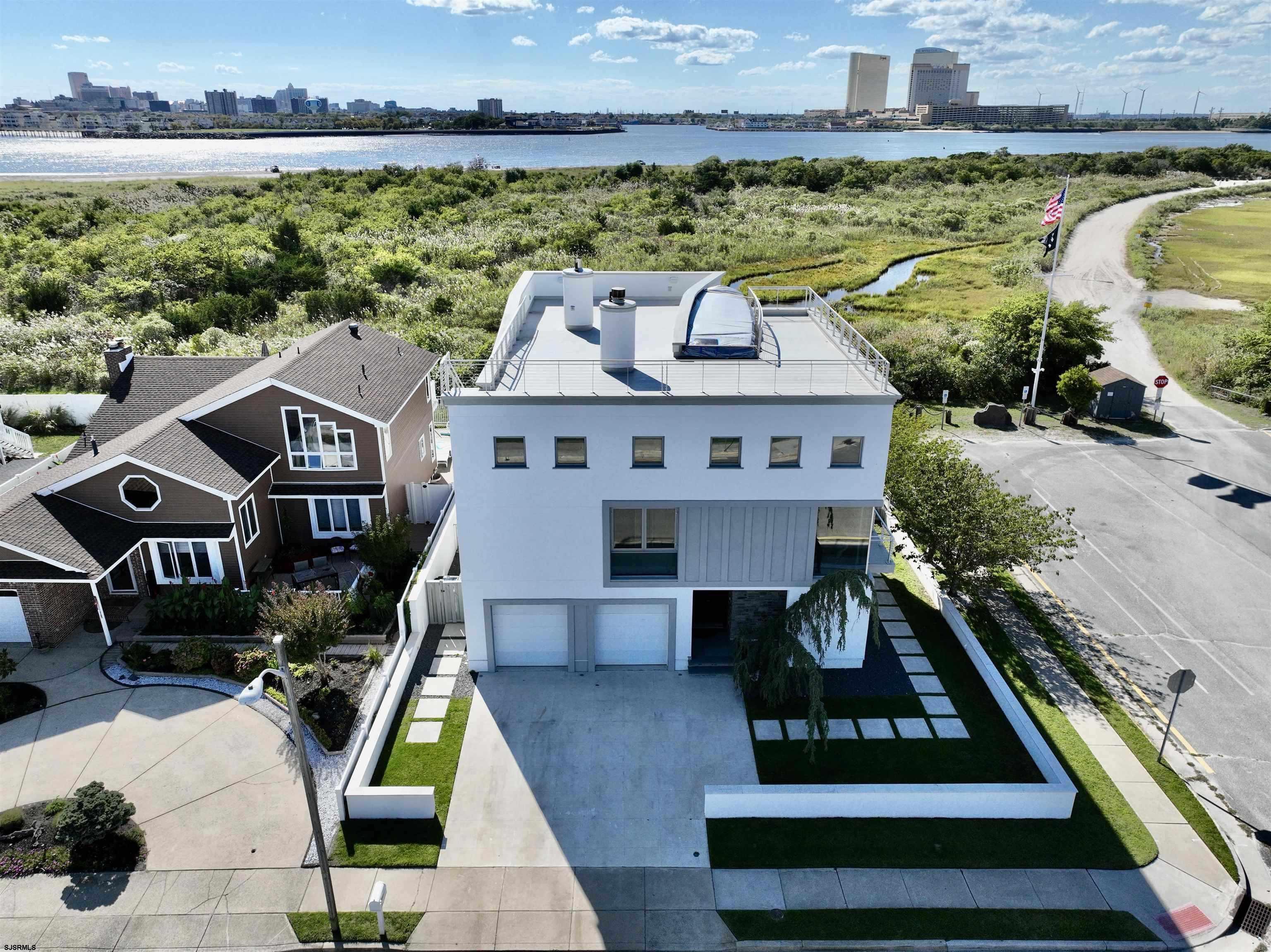 STUNNING ULTRA- CUSTOM Contemporary 5 BD/4.5 BA. BEACH home located in beautiful SEA POINT!  Situated on a corner lot, with direct access to the popular Cove Beach,  this- one -of- a kind LUXURY landmark designed by Italian architect Leopoldo Rosati will exceed your expectations! Dramatic 3 -story foyer entry w/ limestone flooring!  Three- levels plus a roof-top deck captures spectacular sunsets & VIEWS of the Atlantic City & Marina district casino skylines. First level features a laundry room, two guest bedrooms, one an ensuite w/access to the inground heated pool/spa area & private, enclosed outdoor shower. Second Level: Open floor plan w/ Gourmet chef's kitchen featuring Carrera marble counters, WOLF, SUB-ZERO & Asko appl., Renato wood- fired pizza/bread oven, custom cabinetry, pantry, center island, commercial sinks, two dishwashers, full-size built- in wine fridge plus a separate prep kitchen! The dining area boasts floor-to ceiling windows, a relaxing living room area with a gas log double- sided firelpace & adjoining media/ movie room complete with surround sound. The third level houses the gorgeous master suite with private spa bath, walk-in closet storage & views of the pool, Absecon Inlet, & BEACHES!  Two additional ensuite bedrooms are included & entrance to the expansive roof-top deck that offers 360 degree views of beautiful Brigantine! MOTIVATED SELLER! PRICED TO SELL! Call today to preview this unique & amazing home!