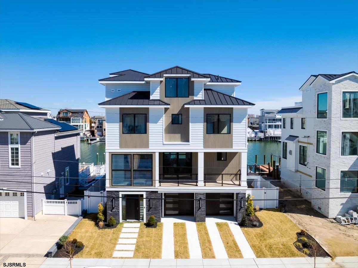**JOIN US AT OUR OPEN HOUSE SATURDAY, MAY 10TH 12-2** HIGH-END, LUXURY PARKWAY BAYFRONT NEW CONSTRUCTION BUILT BY REVOLUTION BUILDERS!! INCREDIBLE, ONE-OF-A-KIND CUSTOM ESTATE WITH 5 BEDROOMS, 5.5 BATHS, IN-GROUND POOL, ELEVATOR & LARGE 3RD FLOOR DECK! You will just fall in love with this highly desirable, secluded location-- one of the prettiest streets on the island! Here is your chance to design your custom bayfront home from the ground up! New bulkhead, multiple boat slips, Hardie Board siding, Andersen 400 series windows & multiple decks to enjoy living life on the water! This custom gorgeous interior will feature top-of-the line finishes, high ceilings, the highest level trim package, & gorgeous hardwood flooring throughout. 4 stories of living!! Ground level with attached two-car garage, large storage area for all of your toys, paddleboards, kayaks, bikes & beach chairs plus a beautiful entry foyer. Spectacular, wide-open main floor of living space with high-end, custom kitchen including Sub-Zero/Wolf appliance package, built-in bar area with large Sub-Zero wine fridge, dining area, living room with built-in fireplace, powder room & mud room. Second floor with 3 large bedroom suites each with their own designer tiled baths including a palatial master suite with walk-in closet, large master bath & bayfront deck! Top floor with 2 more bedrooms with ensuite bathrooms and large deck. Walk to the hottest restaurants, stores, Marina boardwalk & more. NEW CONSTRUCTION & BAYFRONT-- THIS COMBINATION IS HARD-TO-FIND!