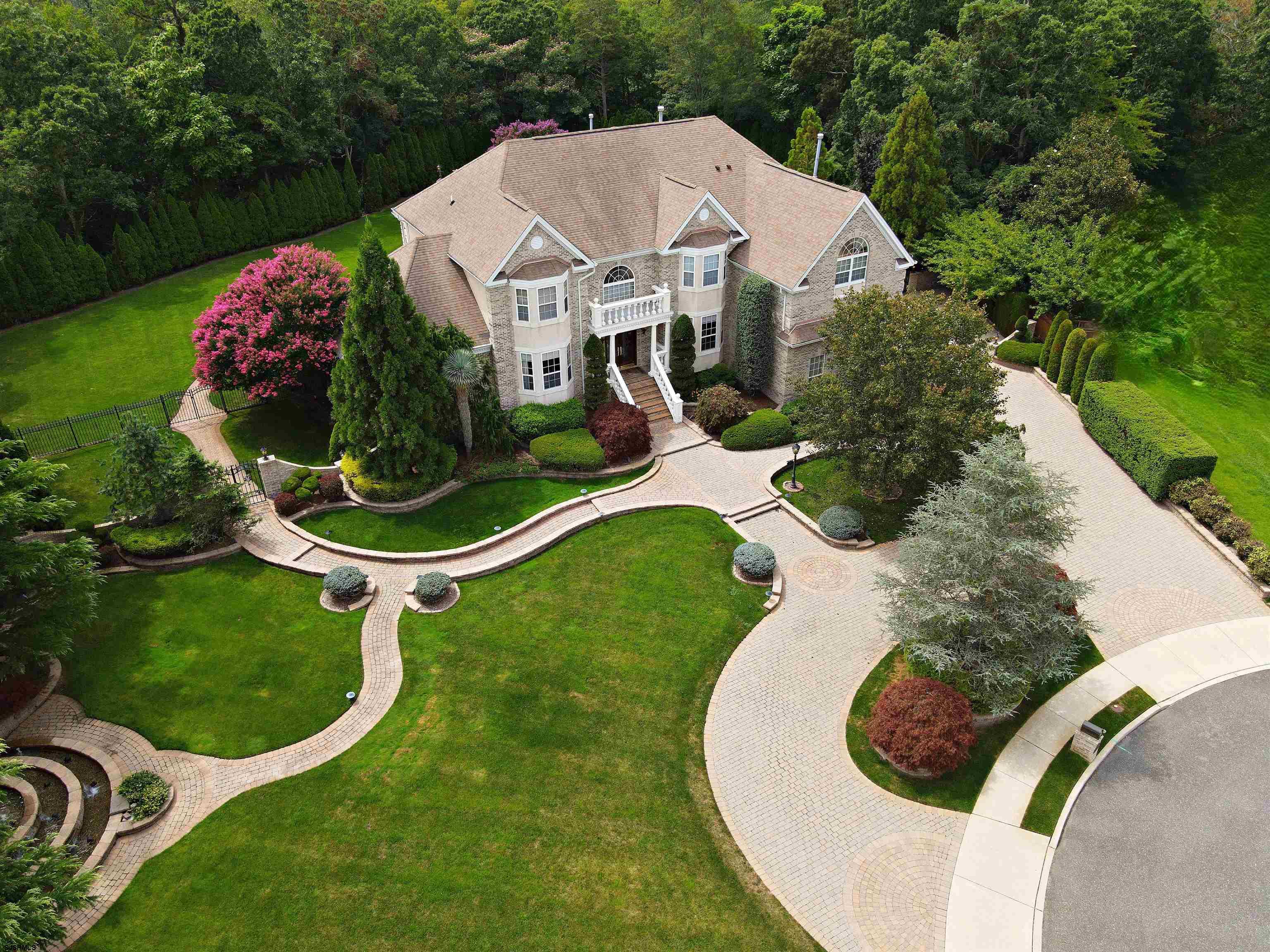 This magnificent Trophy Estate Property incorporates both 22 and 20 Dani Dr. (a separate buildable lot) into its design. The 2 cul-de-sac lots offer outstanding drive-up curb appeal. The exterior of the home showcases 2 fountains, extensive use of brick paver driveways, walkways, retaining walls and huge multi-level patios. Behind wrought-iron estate gates, an unbelievable resort-like backyard awaits! The huge 44,000 gallon saltwater free-form heated pool with a waterfall grotto and LED lighting is stunning. Overlooking the pool is a 2-tier fountain, a large 14' x 32' indoor/outdoor kitchen w/full size fridge, sink, icemaker, Viking Grill/Hood and a generous sitting/TV area. There's a detached 309+/- sq.ft. poolhouse w/full bath & living area w/TV, a zen garden, & a huge outdoor dining area with a 2nd Gas Grill. The rear abuts a heavily wooded backdrop, guaranteeing 100% visible privacy from all neighbors. There's a woodburning firepit, a year-round hot tub, tons of seating, loungers, tables, chairs & umbrellas, and a 10' x 14' Sunbrella cabana w/convertible roof.  A fresh-water commercial well feeds crystal clear water to the pool, the poolhouse, the 12-zone commercial sprinkler system and all 7 exterior hose bibs. There's low-voltage and decorative exterior lighting around the property and hidden surround sound speakers. Facing southwest is a roof solar system providing approx. 25% of the electricity used to power the home.   Inside the home, you'll find an impressive two-story entry foyer and staircase.   There is extensive millwork, exquisite recessed backlit crown molding, and textured and wallpapered walls throughout. The office boasts built-in cabinetry with granite counters. A half bath and first floor hall closet is on this level. There's a formal living room, and an informal living room offering a vaulted ceiling, fan and fireplace. Next to the formal dining room is a conservatory w/granite wet bar, hardwood floors and a mini-kitchen featuring built-in shelving, refrigeration, d/w, ice and a TV area. On the main level you'll also find a granite-topped kitchen, a large island w/seating that opens to a casual dining table, a sitting area, and a pantry. The laundry room is also on the main level. In the 2-level garage, you'll find a 2nd washer & dryer, and #3 of 4 full sized refrig/freezers. The custom-built 2-story 3 car garage features built-in storage bins, cabinets, and a 2-door walk-up staired and carpeted storage area.   There are 4BRs and 4.5 Baths inside the home. The Master BR has a sitting room (EZ convert for BR #5)  featuring a two-way gas fireplace - one of 4 gas fireplaces throughout. His/her custom closets. Gigantic 20 x 25 Master Bath sits over the entire 3-car garage. His/her vanities, 2 TV’s, a lighted makeup table, a two person 6x7 steam shower w/ample seating & shelves, stairs to a round Jacuzzi tub for 2, a separate toilet/bidet room, and a large storage closet hiding the Master Bath's water heater and another water heater w/equip needed for the Master Bath's in-floor heating system. BR #2 has a private full bath inside. BRs #3 & #4 share a full bath. Custom Foil Radiant Barrier Attic.   The all-finished lower level is a 2,697 sq.ft. +/- "English Basement" - half below and half above ground, w/3 full size windows. Extra headroom. Perfect for large dinner gatherings, holidays, kids sleepovers, and all sorts of parties. There's a full bath (#4) and a full kitchen. It has a custom bar that sits 8 w/beer tap, an icemaker (#3), d/w (#3), and a Bar TV.  There's a seating area w/gas fireplace #4, a separate gaming/TV room, a gym with TV, a non-commercial hair & nail salon, and a separate large storage/HVAC area. Built-in cabinets face a big screen TV with surround sound. Incredible 14' x 25' dance/activity floor w/club-quality surround sound, strobe lights and lasers. Use portable chairs and tables to easily convert the space to a large dining area. This is truly one of Atlantic County's Finest Properties!