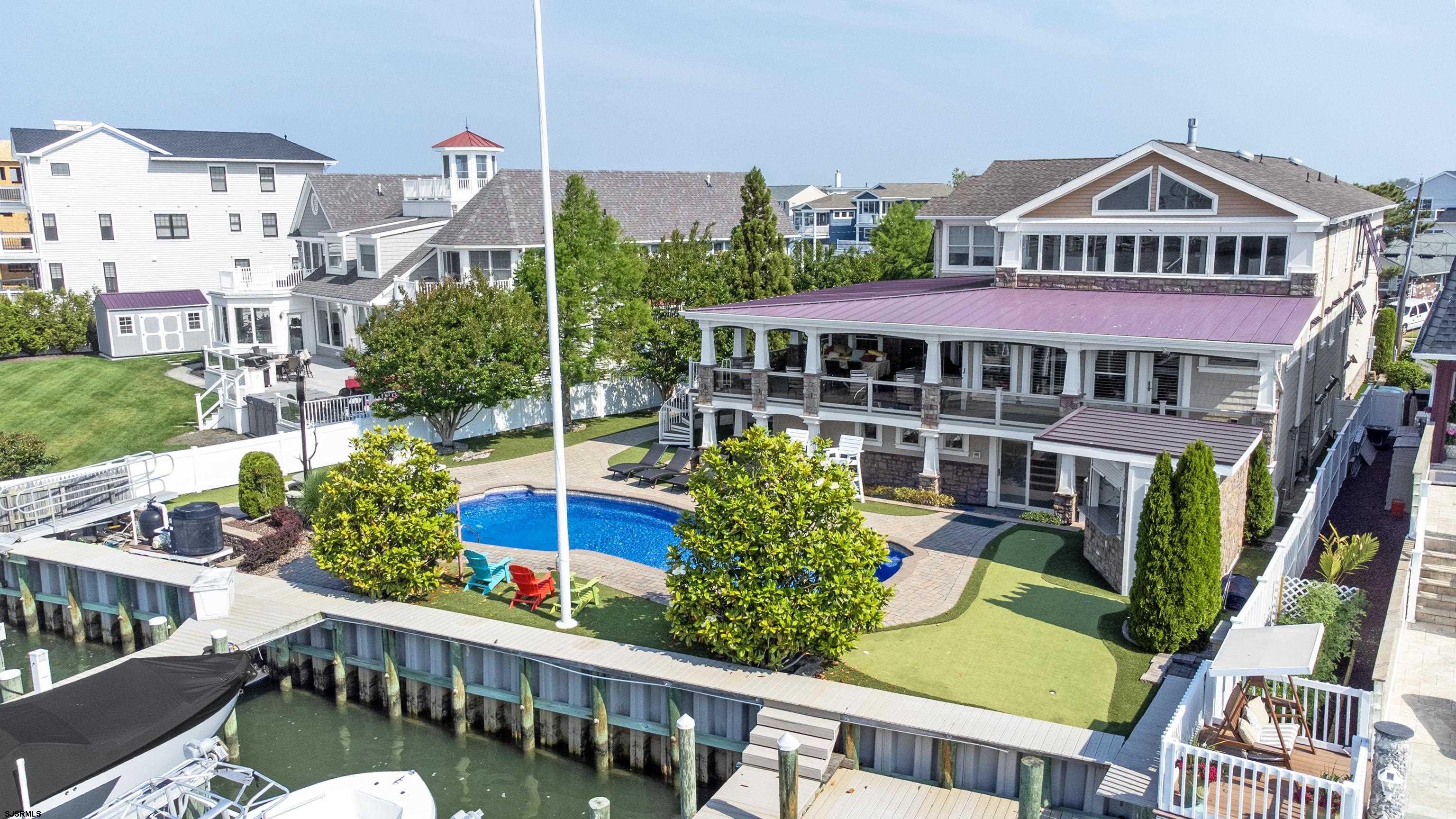 458 West Shore is more than a home - it's a private sanctuary where every detail speaks to refined coastal living.  Nestled in the protective cove of the Island's prestigious Gold Coast, this 6 bed 6 1/2 bath home is thoughtfully crafted for upscale entertaining and serene family living.  If you're craving a show-stopping property with superior boating amenities, lavish indoor-outdoor entertainment, and timeless design, this Brigantine masterpiece is unmatched.  Situated on a Huge pie-shaped lot w/ 100' on the water, the views from all areas of this property are amazing and ever changing.  After a day on the water jump in the large, in-ground Pool to cool off before cooking your catch.  Livin' the Dream....in Brigantine!!