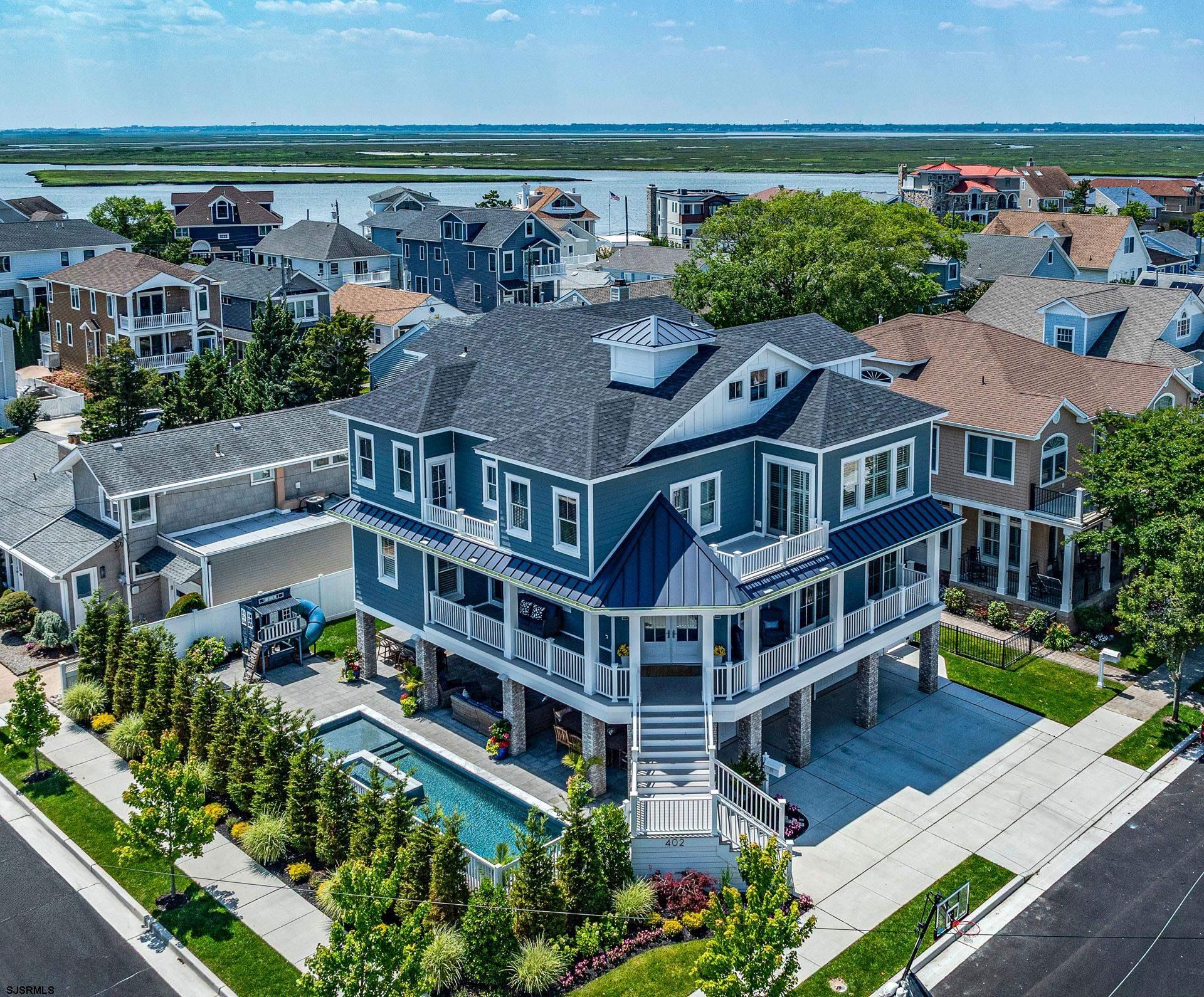 MASSIVE 76.5 x 80 CORNER LOT offering BAY VIEWS of Sunset Canal. Highly sought after PARKWAY area of Margate. Custom-built 4,500 SF masterpiece with 5+ bedrooms & 5.5 bathrooms.  Maximum privacy & space in your additional 500+ SF OUTDOOR LIVING SPACE including custom kitchen/bar with built in Weber grill, sink, refrigerator, & ice chest. Large living areas with brick gas fireplace &  expansive dining area perfect for entertaining. Large Custom POOL with automatic pool cover, 8 person jacuzzi & sun ledge. Screen Logic WiFi Smart pool control, control pool temperature and features from anywhere.  Wonderful wrap around porch with 2 covered seating areas & BAY views. Enter the foyer to the open concept main living level. Spacious living room, gas fireplace & surround sound. Chef’s kitchen is fully loaded with Subzero & Wolf appliances. Free flowing wet bar equipped with Subzero wine & beverage fridges and ice maker. Dining room offers a custom built-it area. Amazing custom built-in office.  This is a BUILDERS HOME. The QUALITY of this home will impress your savviest buyers with no spared expenses. Top tier subcontractors & high quality materials were used throughout. This custom home sits on poured concrete foundation walls at the highest elevation level of 9’. Designer lighting fixtures. Total Connect Smart Home System with alarm system, 7 integrated cameras, exterior lighting, thermostats, and exterior door control. Sonos Smart Sound System  with interior & exterior speakers. Dual unit central air system with 4 zone smart controls & bonus mini split on ground level. Dual tankless water heaters. Large elevator. Generac Generator with 400 Amp electrical service. 2 car oversized garage.  Walking distance to the beach & Marina District. With unparalleled privacy, bay views, and proximity to the Marina District, restaurants and beach this is truly one of the most sought after locations in Margate.