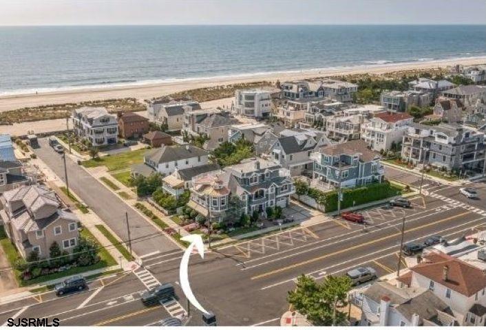 Welcome to 2404 Atlantic Avenue, Longport, NJ a custom built beach house of coastal design.  This beautifully landscaped beach block corner property is situated on approximately 53' x 90' lot containing 5 bedrooms plus den/office, and 5.5 baths in approximate 4800 sf with ocean and bay views.  Stepping into the main entrance, you will be greeted by a spacious light-filled area and a comfortable den leading to the cozy covered front porch. Also on the first level are 2 guest bedrooms, 2 baths, office /bedroom, laundry room, attached garage and a convenient 4 stop elevator.   The second level features a gourmet kitchen complete with Viking Range, Sub Zero Refrigerator, Miele Dishwasher and a walk in pantry.  The creative floor plan includes a circular dining area with a dramatic vaulted beamed ceiling and sun filled windows.   The main living area seamlessly flows onto one of 6 decks perfect for entertaining.  Also featured is a gas fireplace surrounded by beautiful stone complemented by a separate wet bar area. Also on this level are 2 Ensuite bedrooms, a second laundry area and a powder room.  The coastal style continues to the primary suite on the third level with sliding glass doors leading to breathtaking ocean and bay views from the private roof deck. The primary suite also contains a wood burning fireplace, a separate office and a luxurious bathroom with soaking tub and shower.   This seashore retreat is located just steps to one of Longport’s finest beaches and the Atlantic Ocean.  A truly unique opportunity to enjoy a relaxed life style by the sea.