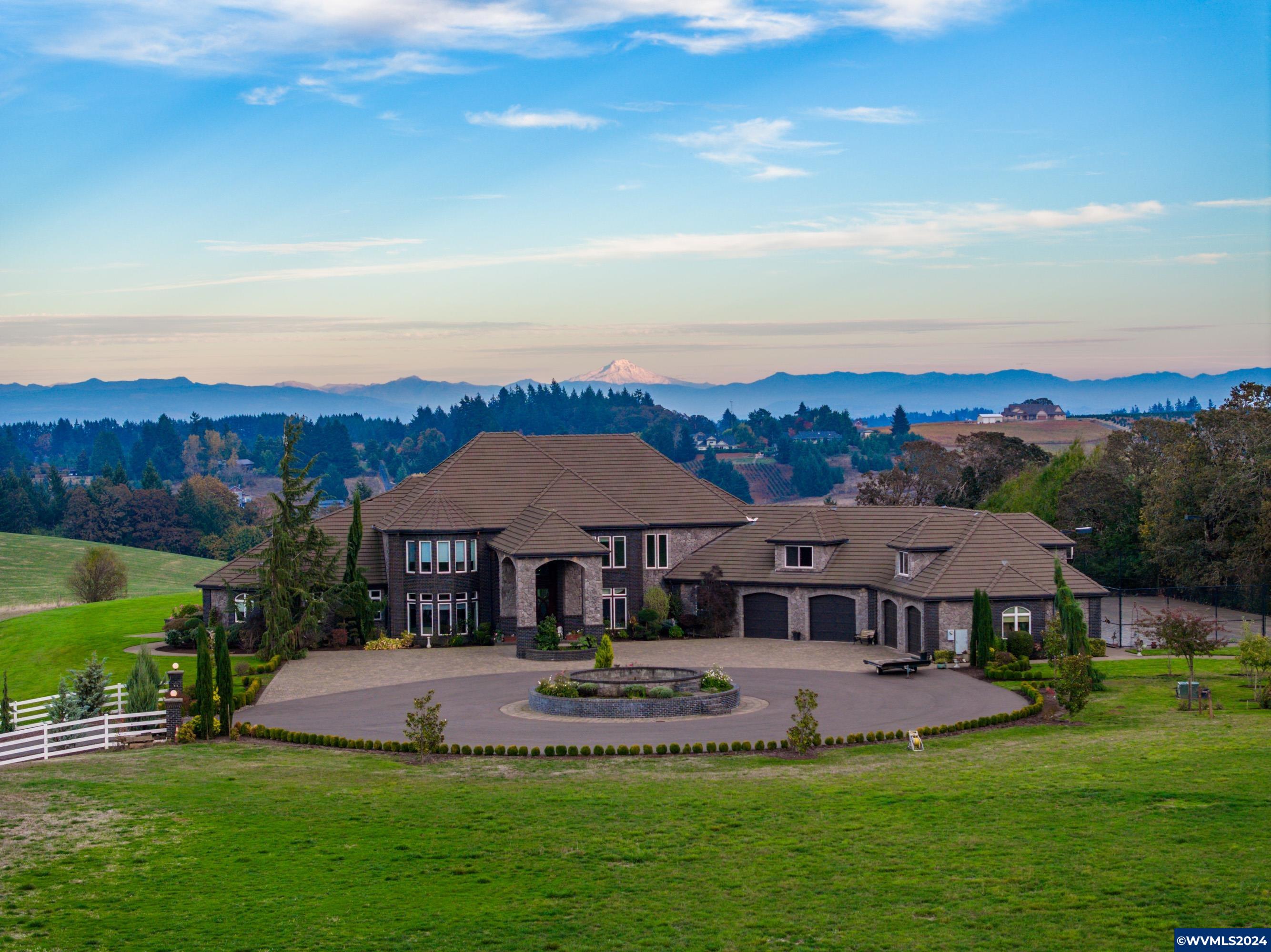 Luxurious Estate with Breathtaking Mountain Views This spectacular 5-bedroom, 7 full and 2 half-bath estate offers unmatched elegance across 11,000+ sq. ft. Nestled in a stunning setting on 32 acres, it’s a dream home for those seeking luxury and comfort. Enter through a grand foyer with towering ceilings and tile floors, setting the stage for the impressive interior. The chef's kitchen with a spacious butler pantry is designed for culinary enthusiasts, while the 6+ car garage and large shop provide ample space for projects and storage. Enjoy hosting in the light-filled main living room, featuring a beautiful fireplace, mantle, and built-ins. The family room has a wet bar and dedicated movie theater, perfect for entertaining. Choose from two formal dining rooms for memorable meals with family and friends. A secret door leads to a hidden cellar with a private bathroom, offering a unique, intimate gathering space. Outdoors, the expansive patio features a cozy fireplace and built-in BBQ, while the fenced sport court with a basketball hoop promises endless fun. Retreat to the luxurious master suite, complete with a fireplace, sitting area, luxury shower, large jacuzzi tub, and his & hers walk-in closets and restrooms. Each of the three upstairs bedrooms has an ensuite bathroom, with access to two balconies through either the third bedroom or the study. The estate also includes a workout room with mirrors and a spacious bonus playroom. With every luxury and convenience, this estate combines sophistication with practical elegance.