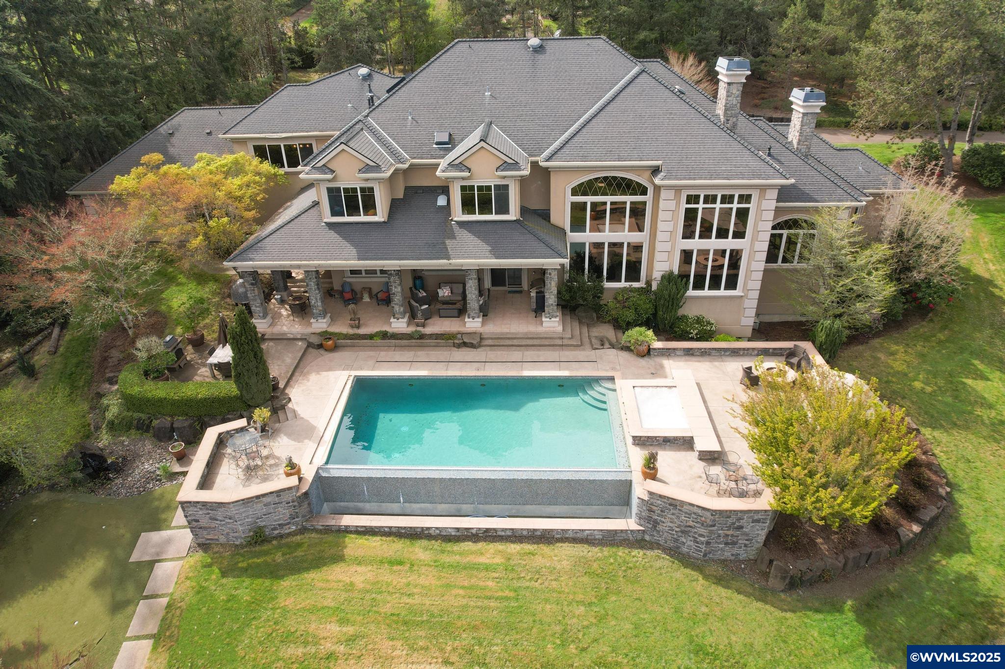 Welcome to 1450 North Albany Rd NW—an exceptional gated estate where luxury meets lifestyle on over 6 private acres in coveted North Albany. Built by Sierra Pacific Construction for the builder’s own family, this 7,255 sq ft home offers craftsmanship you can feel, spacious design you’ll appreciate, and a setting that’s impossible to replicate.Inside, soaring ceilings and walls of windows flood the home with natural light. The chef’s kitchen opens to a grand great room—perfect for hosting or everyday living - and the primary suite is a sanctuary with a fireplace, spa-like bath, heated floors, and jetted tub.Outdoors, the amenities create a true staycation experience: a sparkling pool, full sport court, and extensive trail system that leads down to a serene lower meadow—cleared and ready for animals or even future equestrian use. There's room for a barn, garden, or future pergola tucked into the landscape.A detached 1,100 sq ft guest house (with its own 2-car garage) is already zoned as an ADU—just add a kitchen to transform it into a peaceful retreat or income opportunity. A third detached 2-car garage offers endless flexibility.Beyond the gates, you’re just a short walk to local coffee, groceries, and The Barn—North Albany’s vibrant food truck plaza and taproom. The property offers incredible privacy and views, yet you're only minutes to charming downtown Albany and a short drive to Corvallis.The sellers describe this home as “the most well-built house we’ve ever lived in,” and their vision for the land—barns, gardens, decks between the trees—is your opportunity to create something truly special. Whether you're entertaining, relaxing, or dreaming up your next chapter, this home welcomes it all.