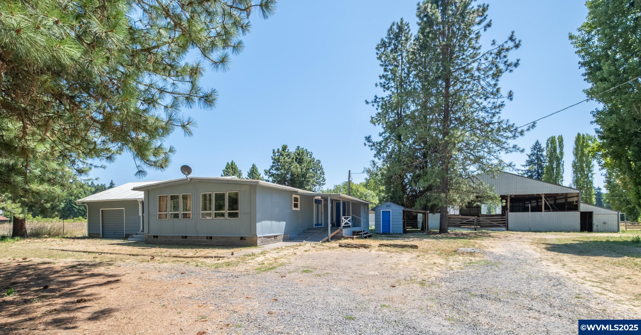Equestrian love on a budget. This lovely home on 3 private acres features an indoor arena that is 60x60 with 5 stalls! This property offers room to grow and make it your own. Enjoy cross fencing for animals, a detached shop for projects or storage, RV hookups, and serene end-of-driveway privacy. Manufactured home is attached to part of the original stick built house that includes the garage and 2 of the 3 bedrooms in the home. Perfect for hobby farming or country living. So much potential—bring your vision!