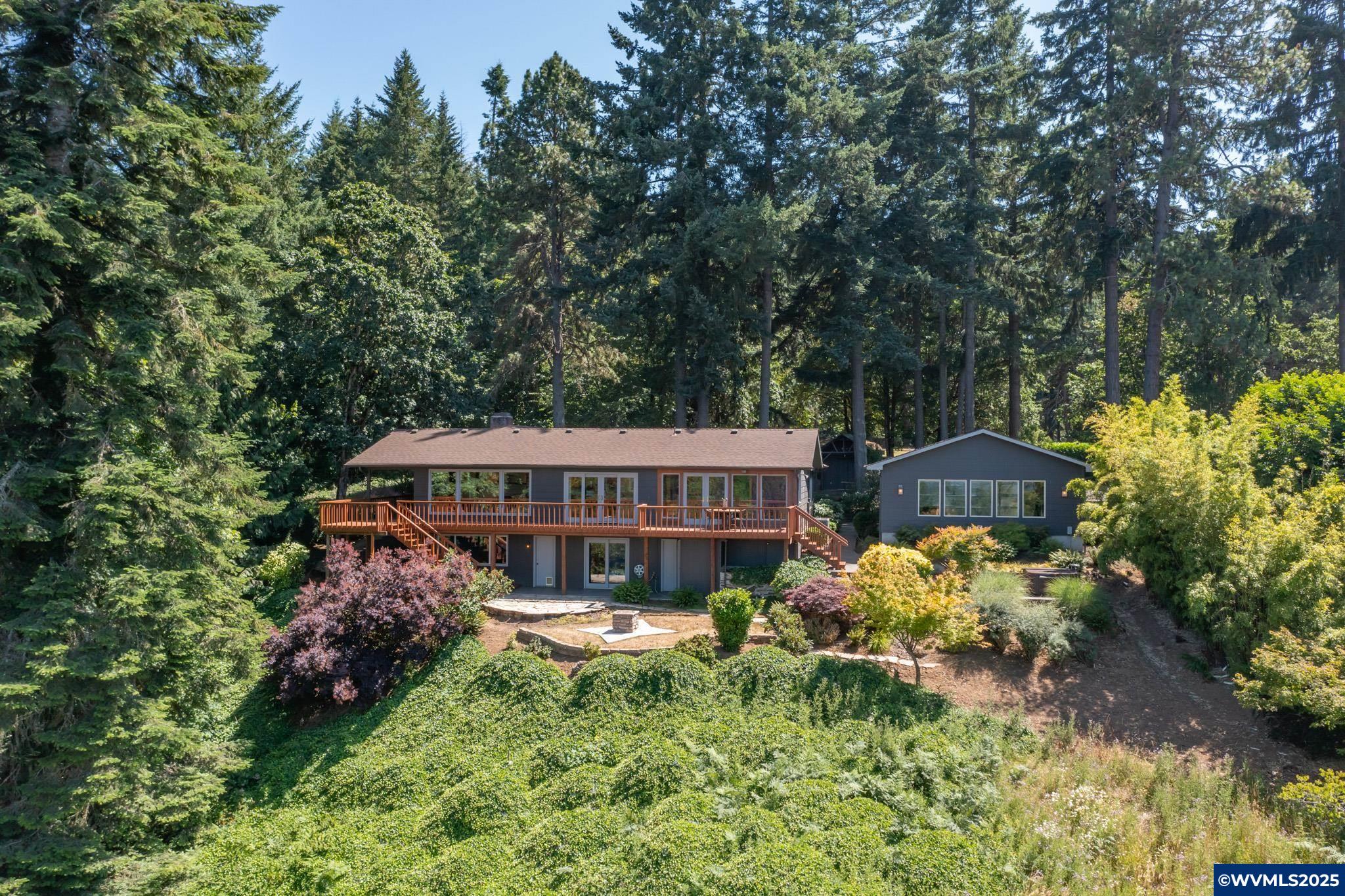 Tucked away on 2.23 private acres just minutes from town, this stunning 2,848 sqft custom home offers space, beauty, and versatility. Features include hardwood floors, two spacious living rooms, wraparound decks, breathtaking views, and a premium heated garage. Ideal for multigenerational or dual living. Enjoy a private hot tub area, greenhouse, and peaceful surroundings—a rare slice of paradise!