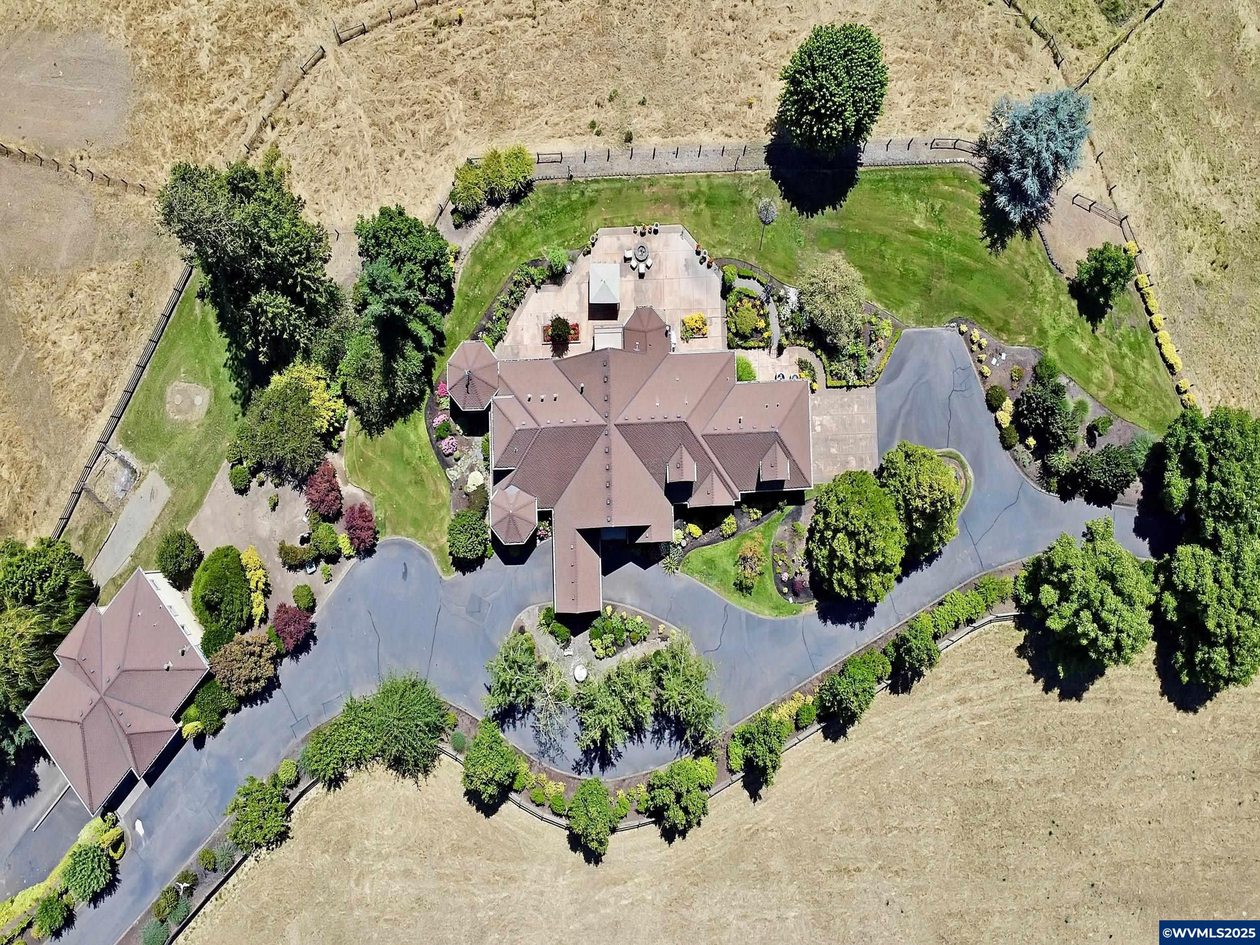 Deer Creek Ranch: Custom estate on almost 30 acres. Light-filled great room, chef’s kitchen, luxe primary suite, and in-ground hot tub grotto. Guest/caretaker quarters upstairs. The Estate features a shop with RV bay, heated dog wash, office, barn, fenced pastures, and remodeled 1920s farmhouse (ADU/studio potential, buyer to verify). Gated drive, manicured irrigated grounds. Minutes to I-5, wine country, and more, ideal for animals, hobbies, events, and multigenerational living.