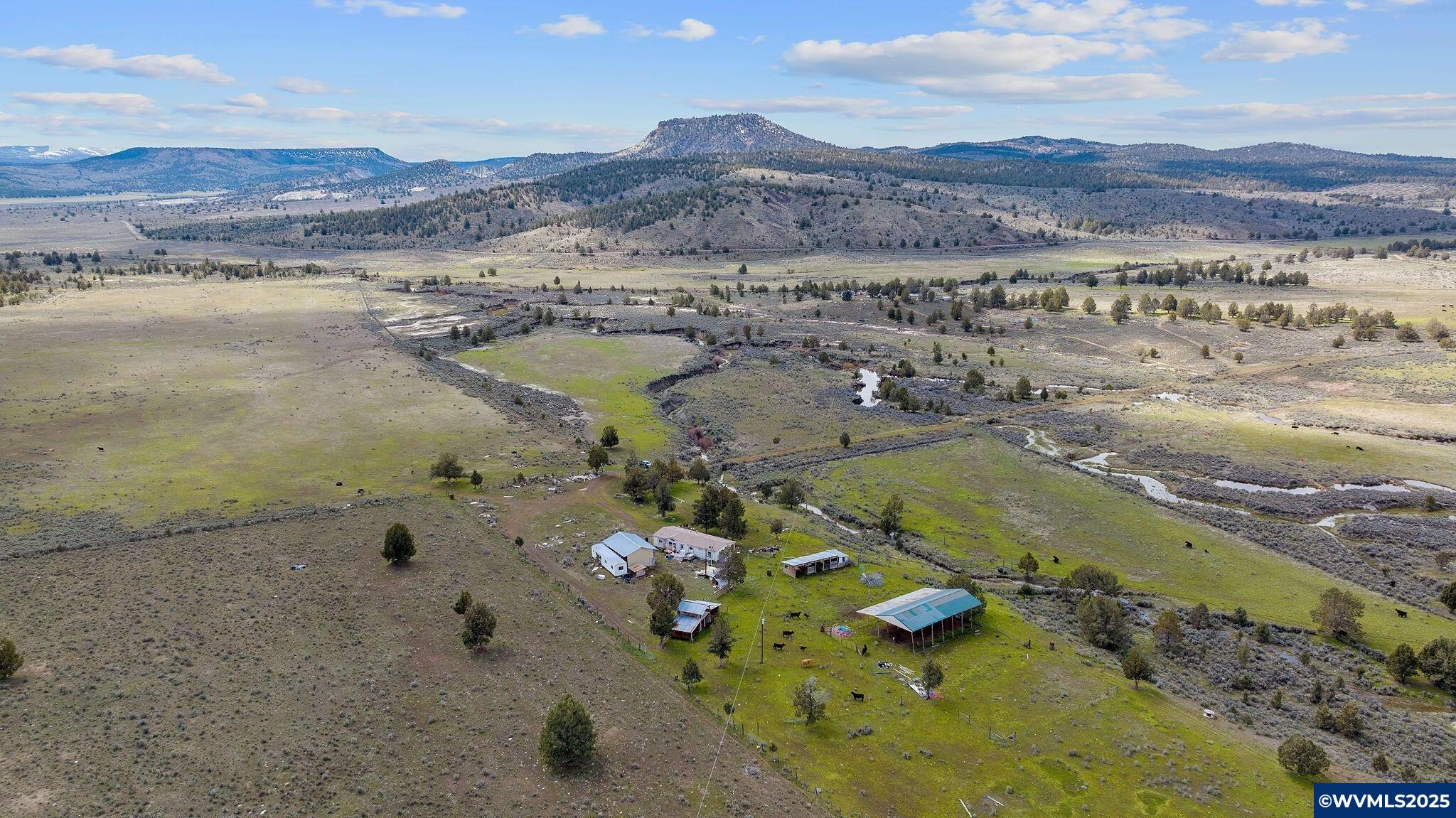 Tackman Ranch is a true high-desert retreat designed for ranching, recreation, and privacy. Spanning 3,190± deeded acres with an additional 1,820± acres of BLM grazing allotment, this property provides the space and resources for a successful cow/calf operation. Located in southeast Crook County, just an hour from Prineville, it lies south of the Maury Mountains and the Ochoco National Forest, offering both seclusion and natural beauty. Water is a key feature here, with 90± acres of water rights dating back to 1886. These rights support hay production to sustain winter feeding. Parrish Creek meanders near the homesite, adding to the setting while nourishing irrigated meadow ground.The ranch includes a functional set of improvements: a barn with animal stalls, a hay shed, and a shop. A 1995 manufactured home currently sits on the property, alongside power and a domestic well. A buyer could update the existing dwelling or build a new residence overlooking the creek and meadows (Crook County approval required).Beyond ranching, the land qualifies for four LOP hunting tags, making it equally appealing for those seeking recreation alongside agricultural use. Tackman Ranch blends heritage water rights, grazing ground, and natural scenery into a well-rounded Central Oregon holding.